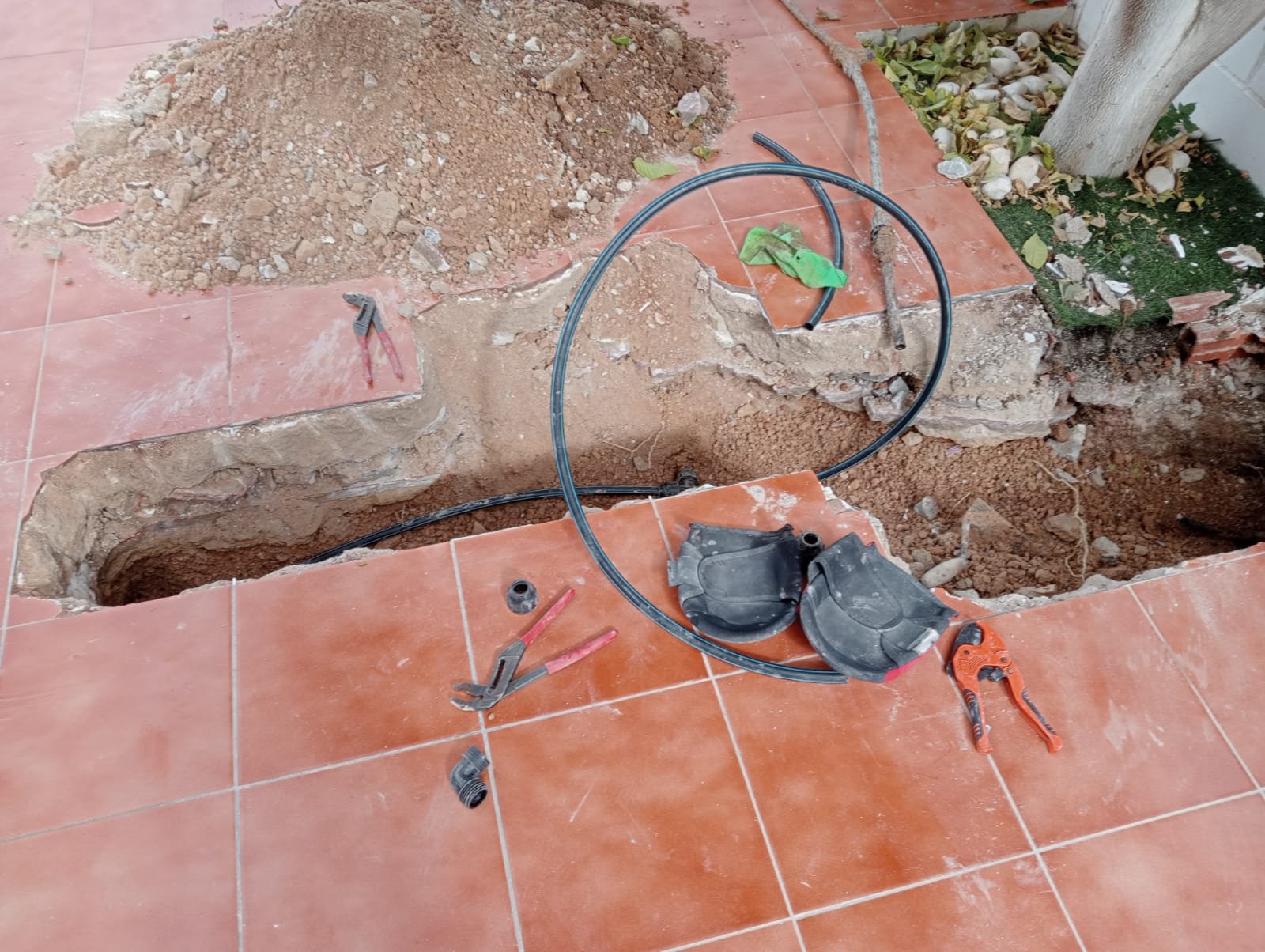 Zanja abierta en un patio para pasar una nueva canalización