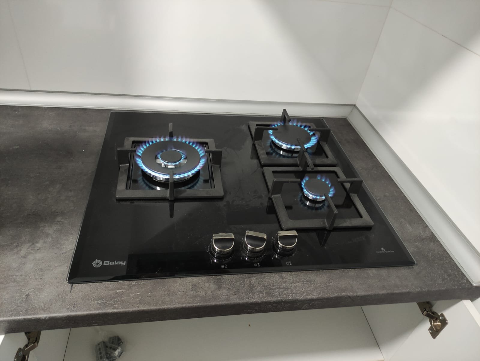 Encimera de gas de tres fuegos recién instalada y encendida