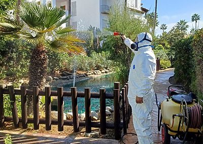 Operario aplicando un tratamiento fitosanitario en una zona ajardinada